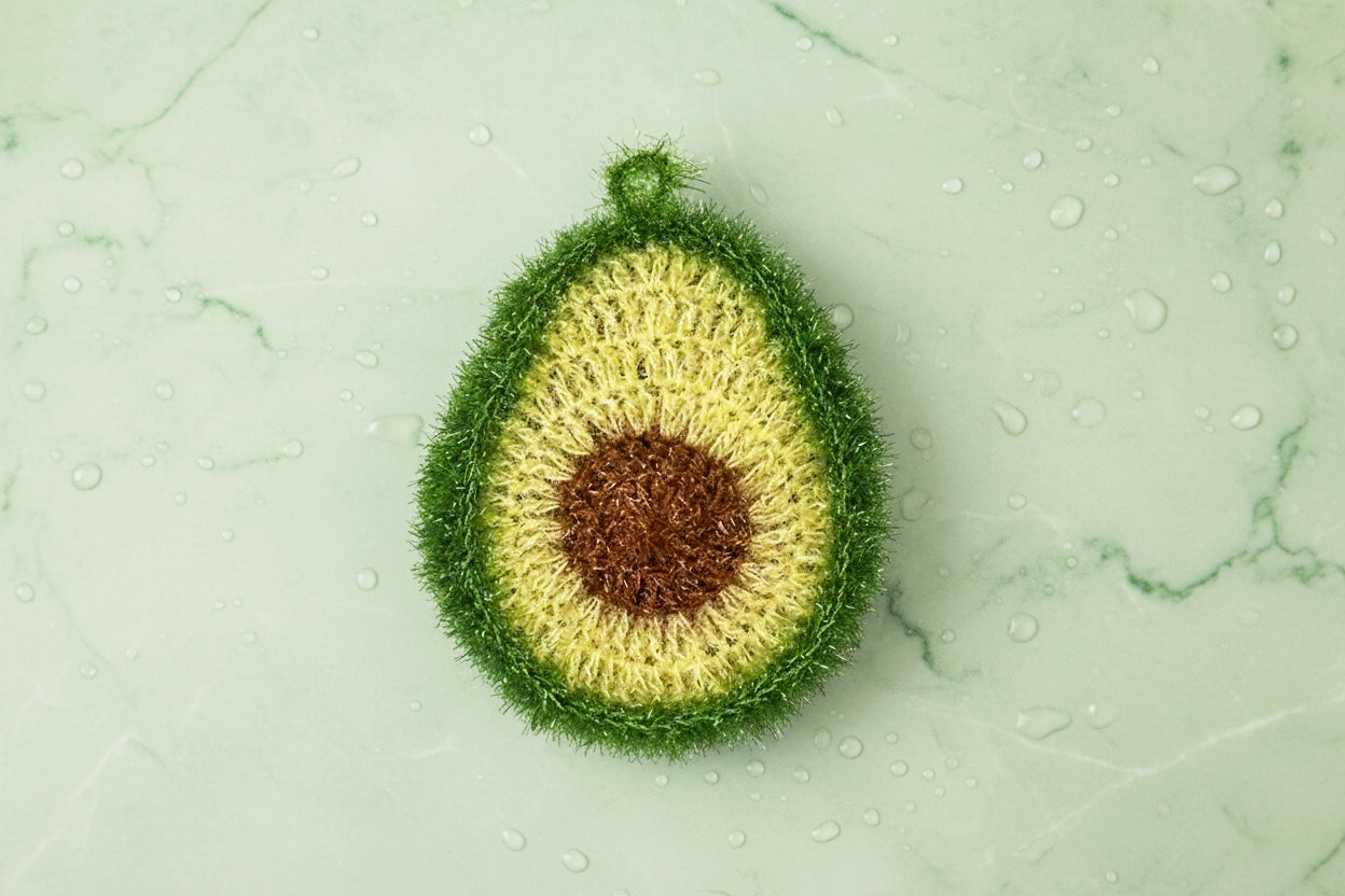 Crocheted avocado dish scrubber on a green marble background