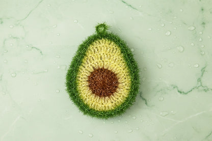 Crocheted avocado dish scrubber on a green marble background