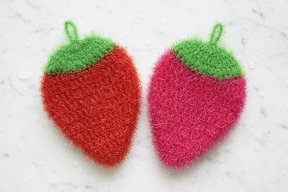 Berry Best Friends Scrubby Set — two strawberry-shaped scrubbers, one red and one pink, on a light background.