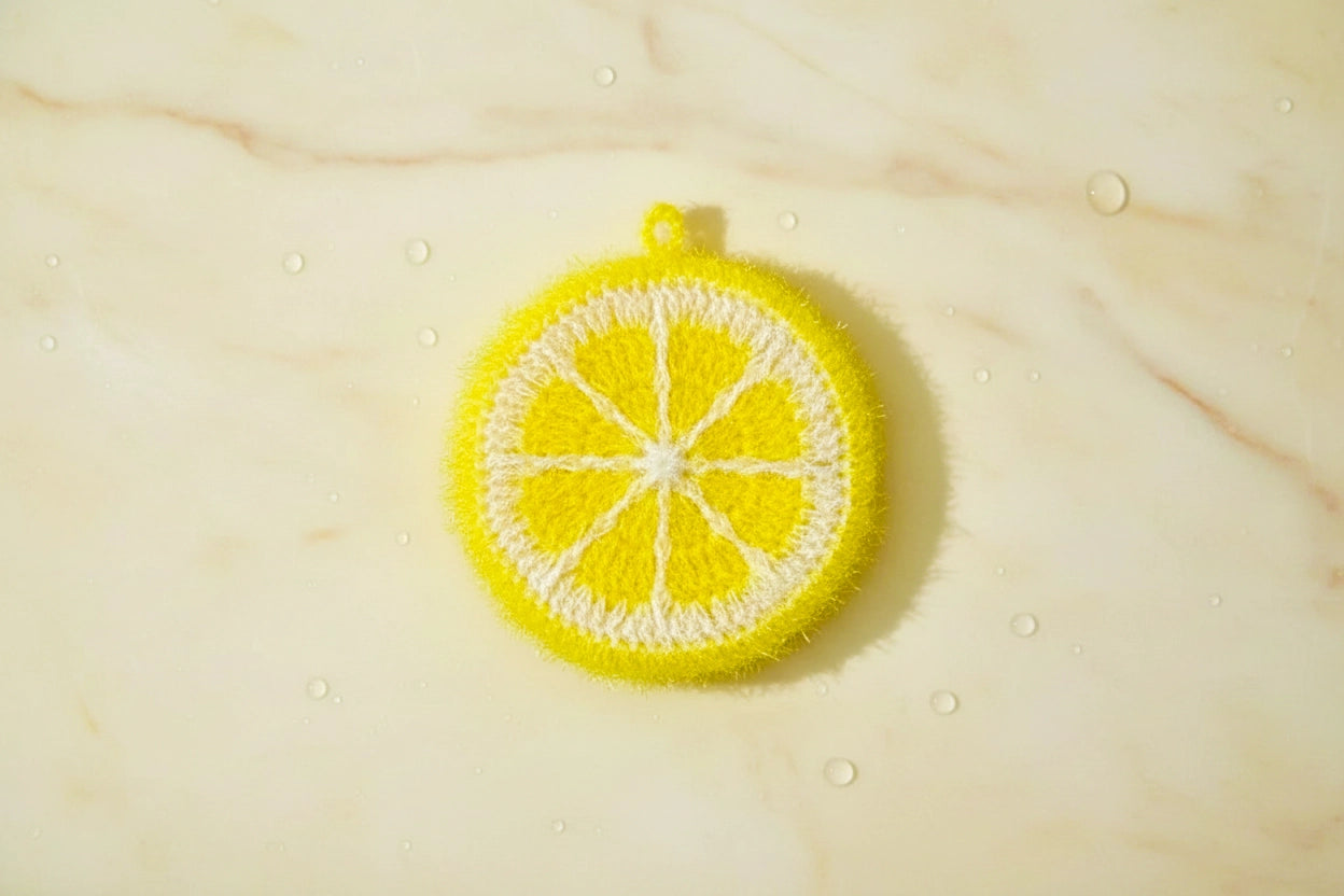 Yellow lemon dish scrubber on a yellow marble slab.
