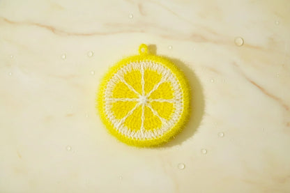 Yellow lemon dish scrubber on a yellow marble slab.