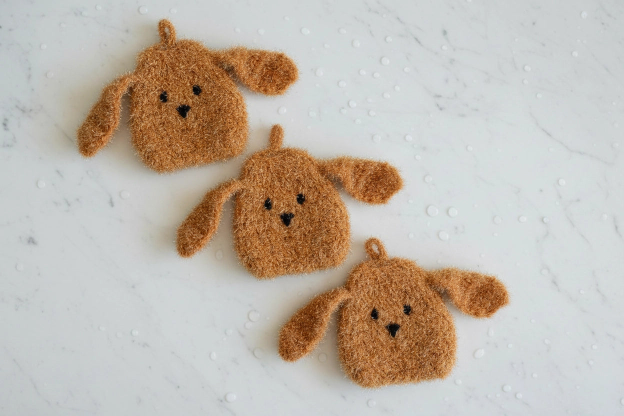 Three brown doggy dish scrubbers on a textured white surface