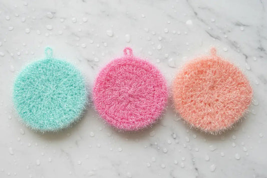Three colorful scrubbies on a marble surface
