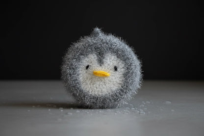 Small crocheted penguin dish scrubber on a dark background